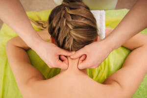 woman having neck and shoulder massage in spa center