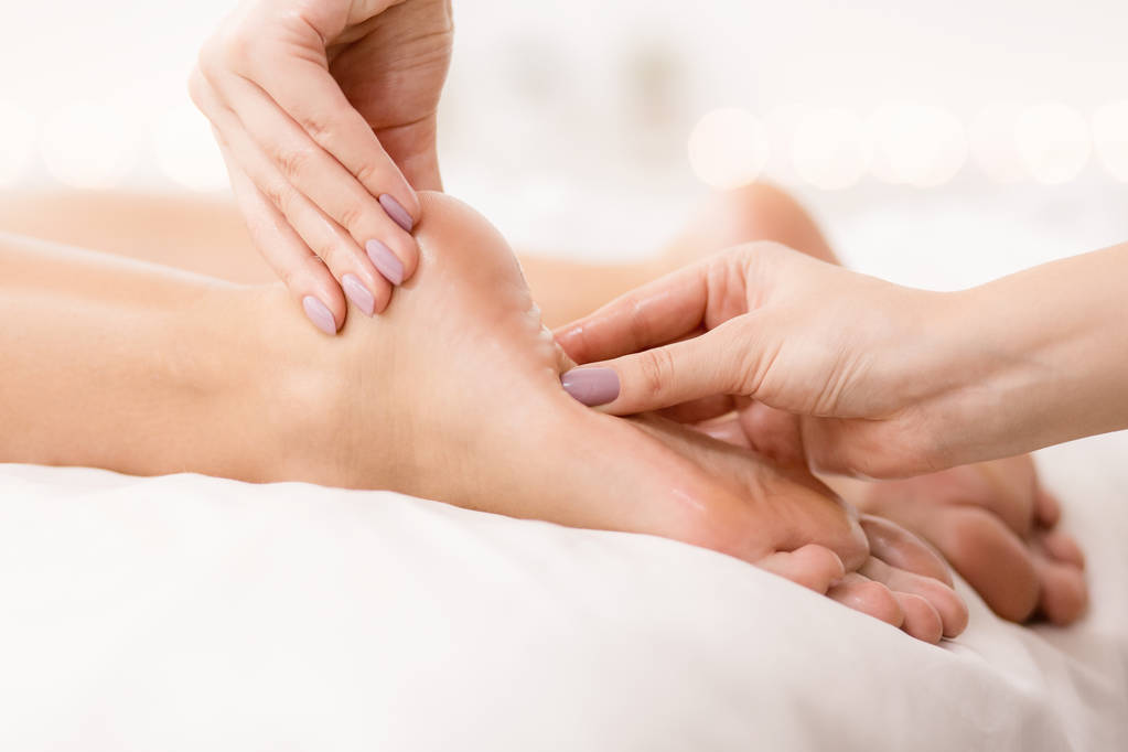 feet care. woman receiving foot and finger massage